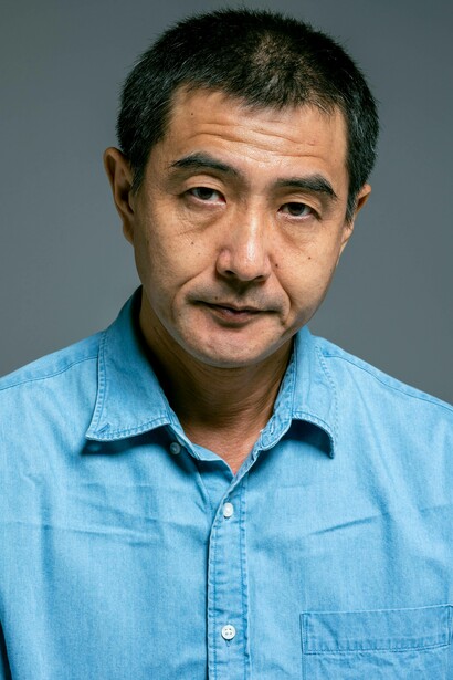 Primo piano di uomo con uno sguardo diretto e leggermente assente in una espressione seria e contemplativa