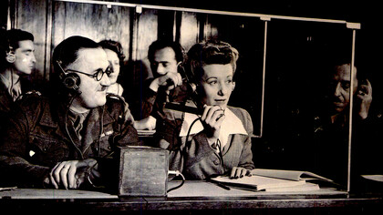 Die Dolmetscher bei den Nürnberger Prozessen: Dolmetscher im Saal bei der Arbeit; v.l.n.r.: Capt. Macintosh, British Army, (Franz.-Englisch), Margot Bortlin (Deutsch-Englisch), Lt. Ernest P. Uiberall (Monitor)