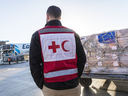ECHO and IFRC personnel monitor the loading of humanitarian supplies bound for Gaza, helping to deliver essential aid to civilians affected by conflict and displacement