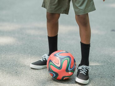 Nossa visita ao estádio era memória e lição. Entre um chute e outro, crianças corriam pelas ruas, chutavam tampinhas de garrafa como gols impossíveis — alquimia de azar e esperança