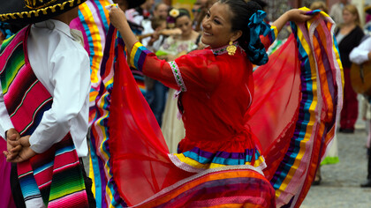 Dança folclórica mexicana: casal se olha com afeto buscando a cumplicidade