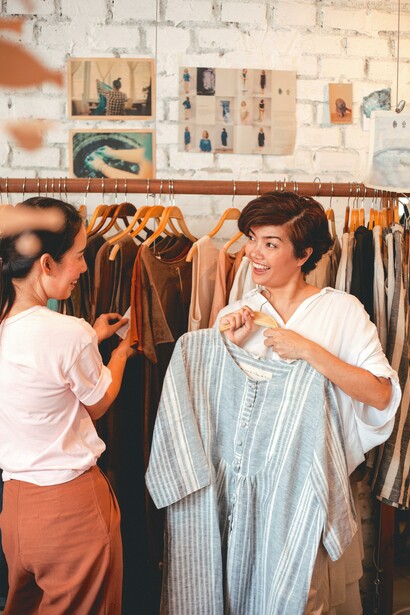 Moças garimpam roupas em loja secondhand