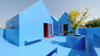 Didden Village in Rotterdam, Netherlands, uses vivid blue forms to create a symbolic rooftop landscape that blends architecture with imagination