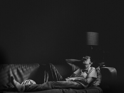 A troubled person sits in the dark. Low self-esteem is a problem that derives from an individualistic model of education