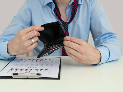 A man displays his empty wallet, highlighting issues of poverty, low wages, and the need for a living wage