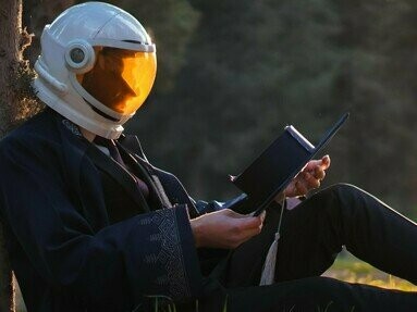 Homem de capacete reflexivo sob uma árvore. O território espacial é autêntico e sustentável. Ele não depende da presença humana. Renova-se em ciclos, reconhece a sua integridade ecológica e se deixa mercantilizar. Fazemos trocas inconscientes com essa malha viva, densa em significados subtis.  Quando nos abrimos a uma conexão consciente com o espaço físico, somos acolhidos pela pertença

