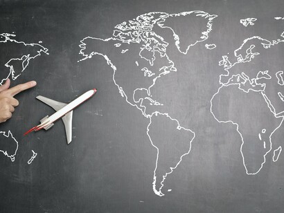 An airplane on a chalk board with a map of the world 