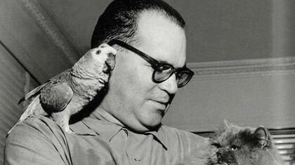 João Guimarães Rosa em sua casa segurando seus animais de estimação no ombro e junto ao peito