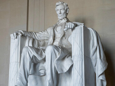 The statue of Abraham Lincoln in Washington, D.C. seated solemnly, reflecting the enduring ideals of democracy and equality