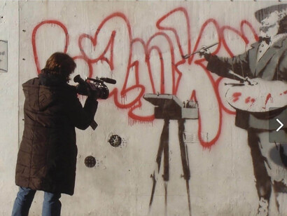 Myself and one of Banksy graffiti on the streets wall, London. Courtesy of Art of Banksy Gallery