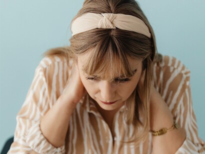 A woman with hands behind her neck attempting to figure out the meaning of her soul