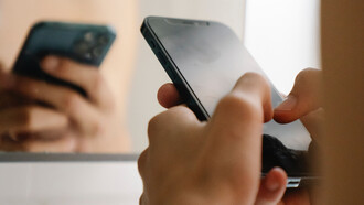 Pessoa recém desperta checa o celular no banheiro antes de escovar os dentes ou tomar banho