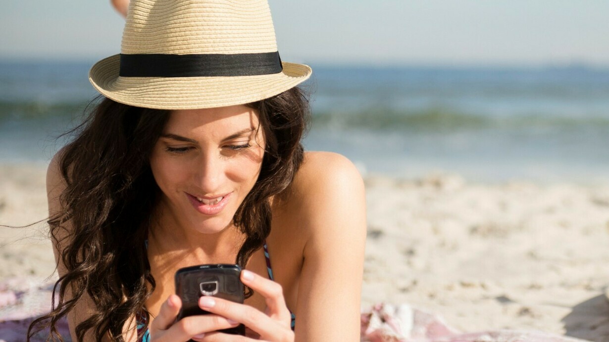 Chateando con el móvil en la playa