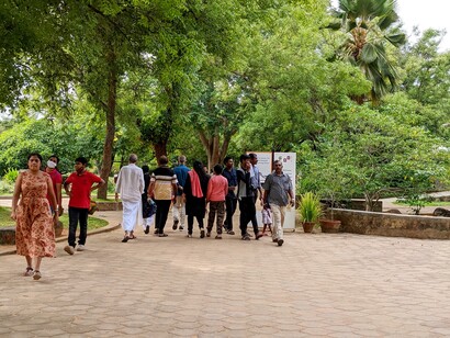 Gli abitanti provengono da tutto il mondo e collaborano in progetti educativi, agricoli, artistici e culturali, condividendo risorse e responsabilità. Persone passeggiano a Auroville, India