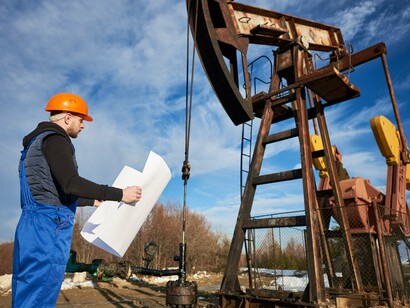 An engineer inspecting an active oil pump, representing the strategic link between energy security and geopolitical influence