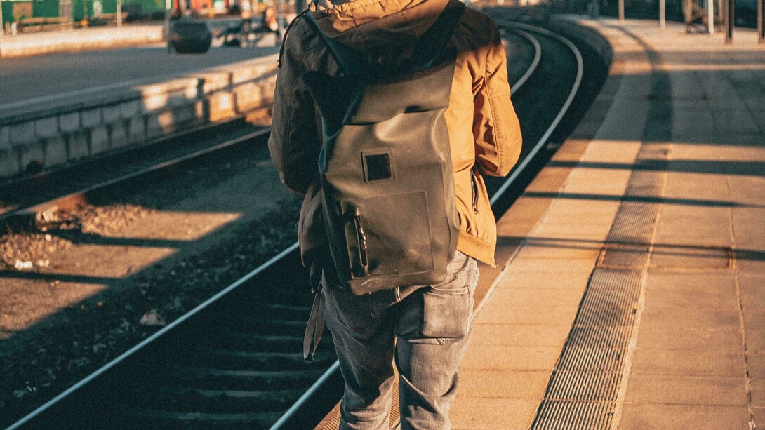Homem caminha por estação de trem. Quando falo em viagem, não me refiro a apenas uma viagem para outro país, mas uma viagem às vezes para uma cidade vizinha, para outro estado, uma viagem que faça em apenas um dia ou faça em um final de semana, em um feriado ou mesmo em duas semanas