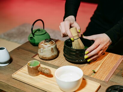 A person performing a traditional matcha tea ceremony