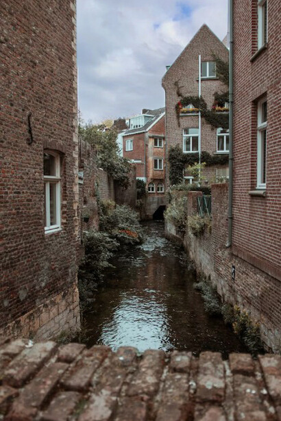 By the calm river in Maastricht, a brown brick building rests among quiet houses and timeworn facades, echoing the charm of the Netherlands