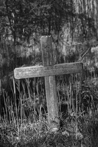 Croce in legno nell'erba per rappresentare il seppellimento di un uomo
