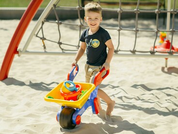 A group of children playing together in a sandy playground