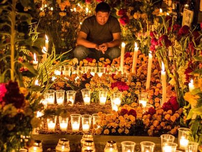 Hombre celebra el Día de Muertos en un cementerio de Oaxaca, México