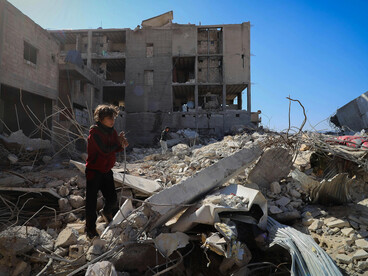 A boy stands on the ruins in Idlib, Idlib Governorate, Syria
