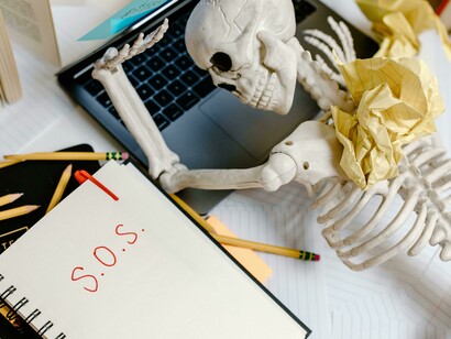 A symbolic skeleton slumped from exhaustion, illustrating how losing touch with rest drains us to the bone