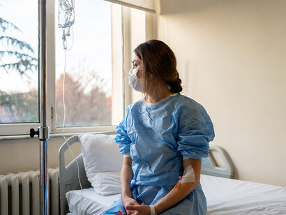 A woman sits alone in a hospital room, surrounded by silence and uncertainty
