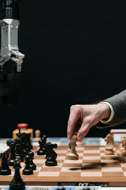 Man moving pawn in game against machine