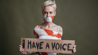 Una giovane donna mostra la scritta “Io ho una voce”