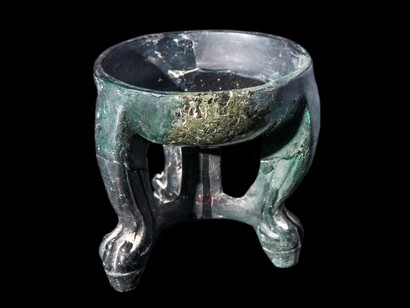 Copa-trípode con terminaciones de patas de león. Siglo V a.C. Serpentino negro, gris y verde. 12 x 12 cm. Persépolis, Fars, Irán meridional
