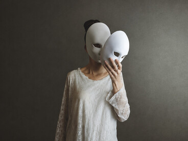 A woman removes a mask from her face, only to uncover another, illustrating the complex layers of identity and the difficulty of exposing one's authentic self