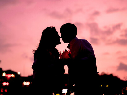 A couple sharing a quiet moment against the fading evening sky, reflecting a devotion stronger than distance and uncertainty