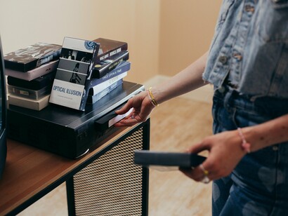 A girl inserting a tape into the VCR, reflecting the timeless habit of returning to beloved narratives