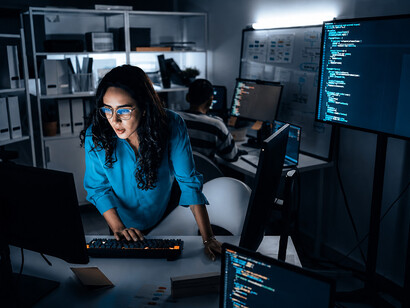 Female programmer using an AI assistant while developing software in a modern office