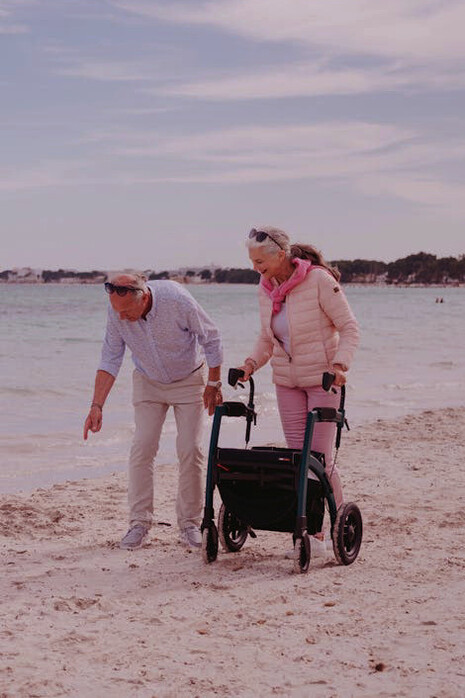 This retired couple takes a serene stroll on Mexico's beach, symbolizing the resilience needed in the face of fluctuating currencies and economic uncertainties
