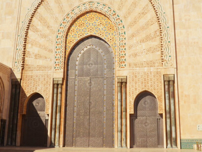 The majestic doors and ornate arches of the mosque in Casablanca, Morocco, provide a welcoming entry for worshippers seeking peace and spiritual renewal during the blessed month of Ramadan