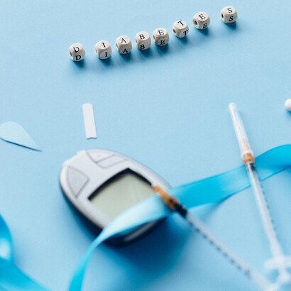 "Diabetes", medidor de glucosa en sangre, jeringas y agujas, y cinta celeste