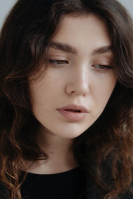 Modelo com pouca maquiagem e blazer preto mais folgado dando liberdade e conforto ao seu corpo