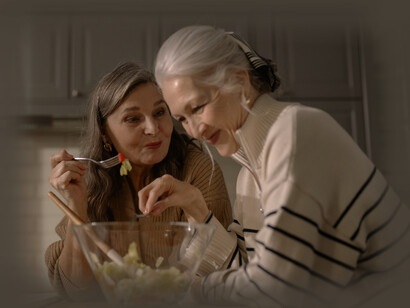 The mother with AD eats a salad full of vegetables with her daughter