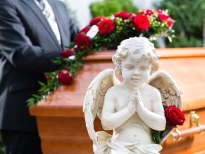 Figura de un ángel junto a un ataud