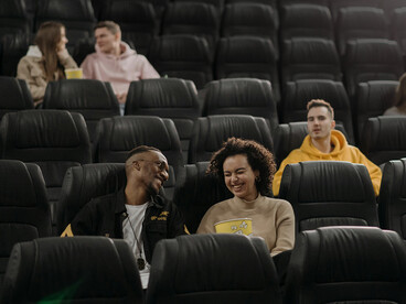 People seated in a movie theater watching a film together