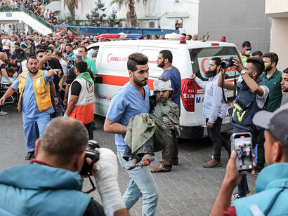 Medics rush an injured Palestinian child into Al-Shifa Hospital in Gaza City following an Israeli airstrike on October 11, 2023, reflecting the toll of war on civilians