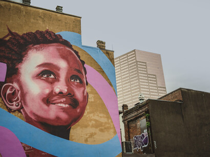 A graffiti-covered wall on an aged building in the city on a cloudy day