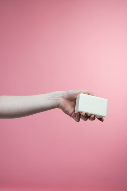 A hand offering a soap bar symbolises the need for sanitisation during the Pandemic, Covid-19
