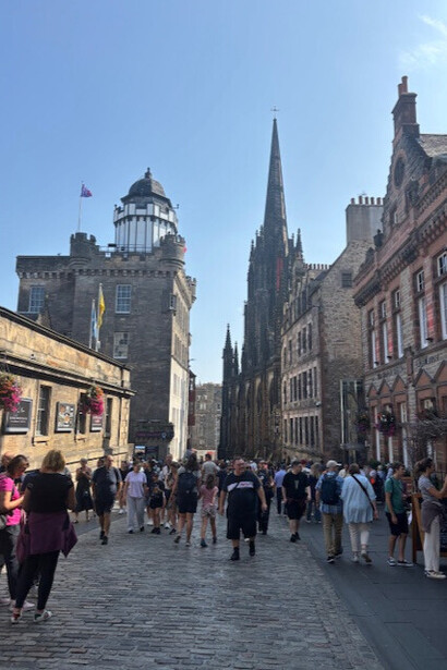 The Royal Mile in Edinburgh, Scotland. The street gently slopes downhill, framed by tall medieval buildings on either side