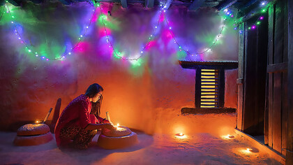 Nepalese sister lighting traditional lamp during Tihar festival, Nepal