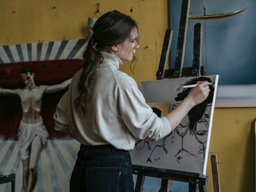 An artist bringing a portrait to life with deliberate brushstrokes, representing the craftsmanship behind Satoshi Kon’s cinematic vision