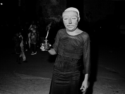 La bruja del volcán, parte de la Fiesta del Torovenado. La figura es compuesta por un ser masculino que usa una máscara de madera y un disfraz femenino, mientras sostiene un pequeño candil. Masaya, Nicaragua
