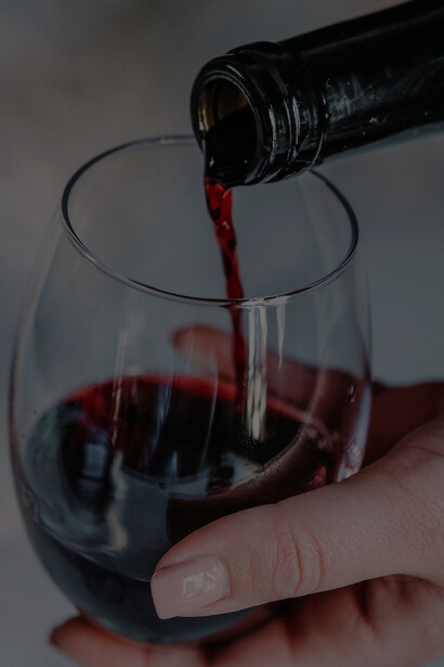 A person gracefully pouring wine into a crystal-clear wine glass